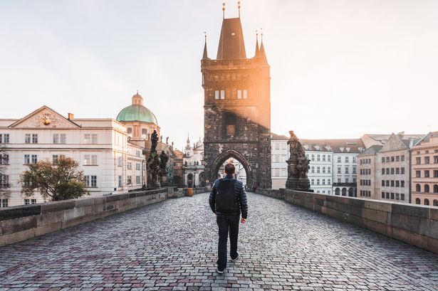 Rear view of a man walking on the Charles Bridge in Prague, Czech Republic