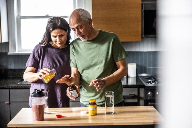 Senior couple taking vitamins at home
