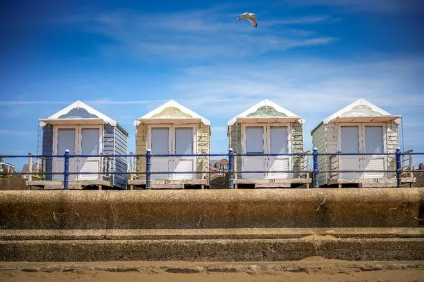 Beach huts on the promenade overlooking the beach and the Irish Sea