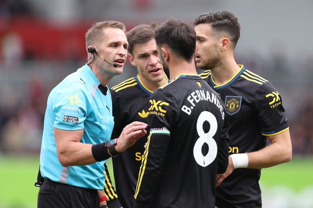 Craig Pawson speaks to Bruno Fernandes and his Manchester United teammates.