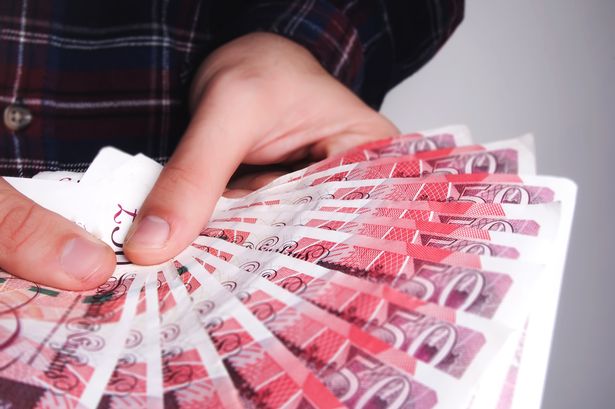 Man Holding fifty pound notes