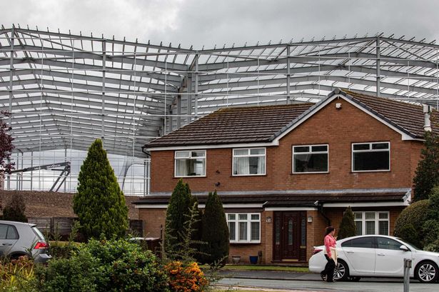 The towering steel structure imposes itself over the semi-detached homes in Wigan