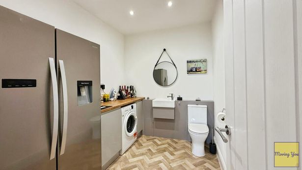  Toilet in open-plan utility room.