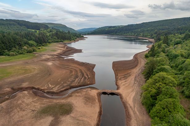 an aerial view of a two-arched stone bridge believed to date back to 1800 which has been exposed due to low water levels at the Llwyn-on reservoir in the Taf Fawr valley 