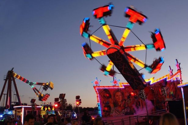 Thrill rides, lit up on a darkening evening 