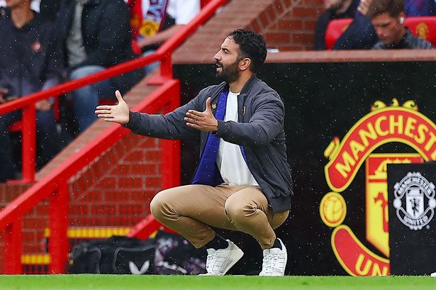 Man United boss Ruben Amorim raises his arms up 
