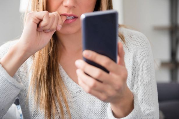 A woman looking at phone worried