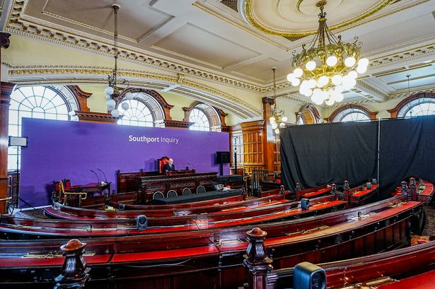 Chair Sir Adrian Fulford sitting inside the hearing room at Liverpool Town Hall