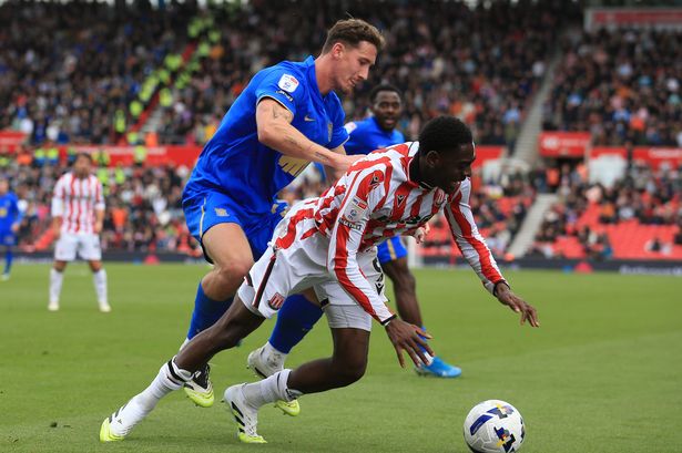 Phil Neumann of Birmingham City (L) defends against Divin Mubama of Stoke City.
