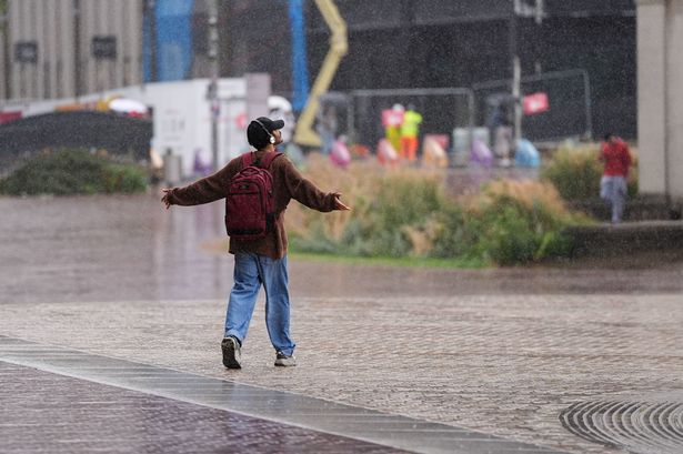 A man embraces a rain shower in Birmingham