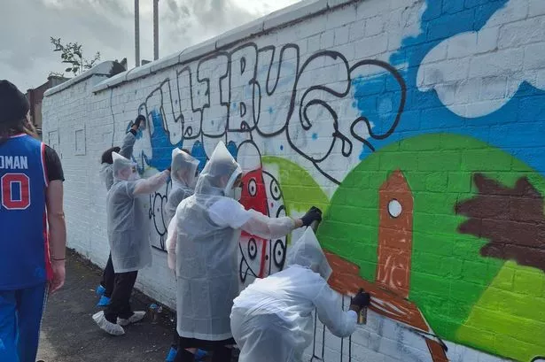 Young people work on the murals