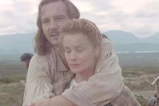 A man embraces a woman 