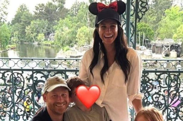 Harry and Meghan with kids, hugging them, with their faces concealed with love heart emoji