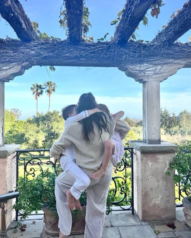 Meghan Markle holding Archie and Lilibet while standing on balcony