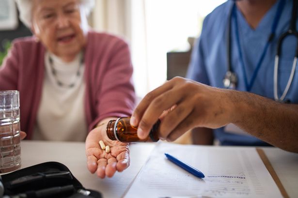 Woman taking pills from doctor, generic