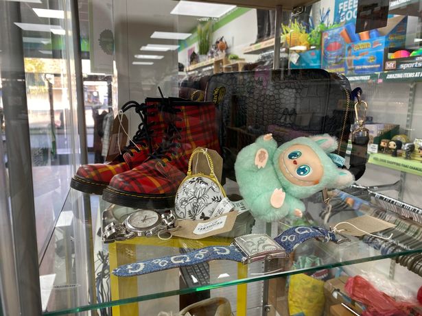 Labubu doll and Dr Marten boots in a glass cabinet