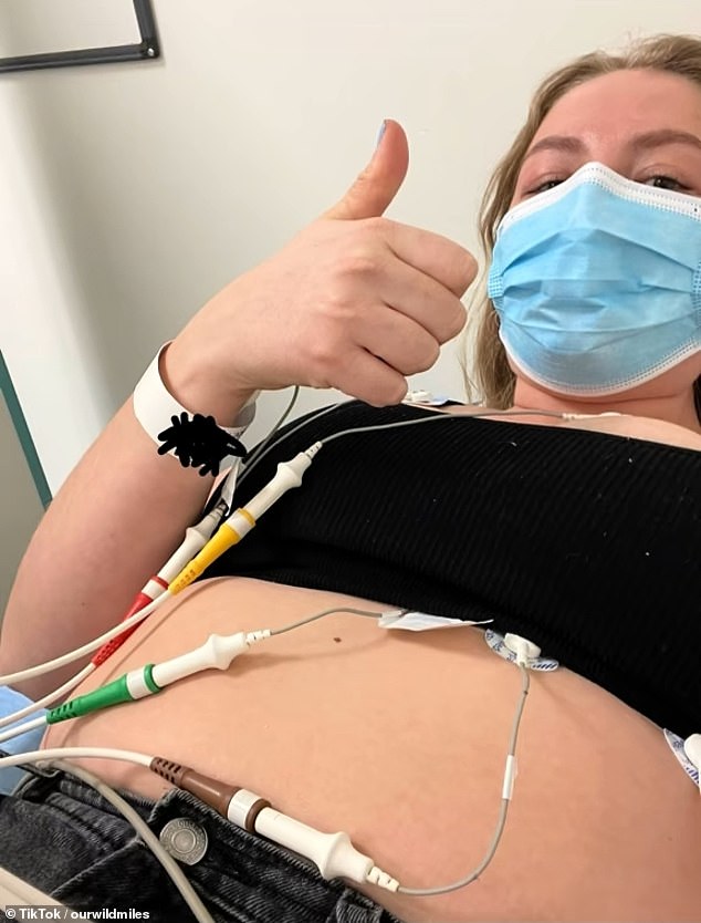 A woman shows wires coming from her body during her experience at flu camp