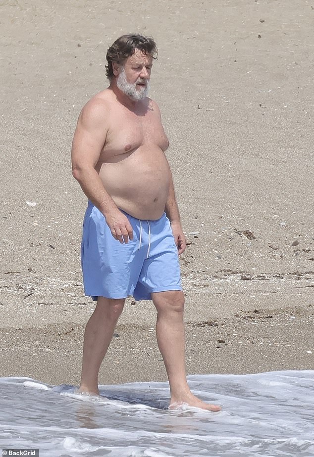 The Hollywood actor, 61, was seen soaking up the summer sun with his ladylove in blue board shorts as they relaxed on a beach in Marbella