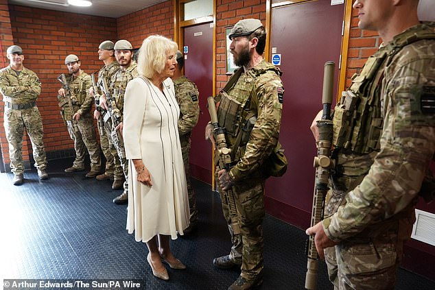 The queen, who paired her monochrome dress with beige suede shoes, took the time to speak to individual soldiers during her visit