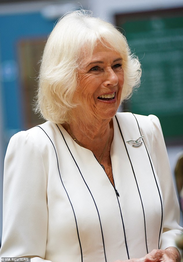 Queen Camilla (pictured) looked elegant in a white dress today as she visited the New Normandy Barracks in Aldershot