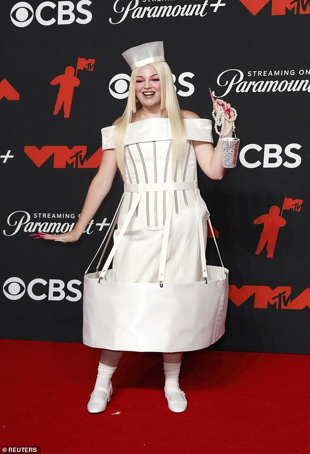 Actress and comedian Megan Stalter opted for a white gown that had a large round piece of fabric at the end of the skirt. She paired the strange ensemble with a bedazzled Dunkin bag