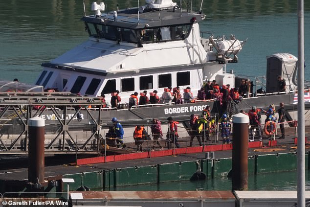 A group of people thought to be migrants are brought in to the Border Force compound in Dover, Kent, on Tuesday