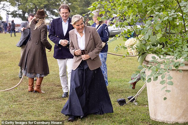 Matching her niece, she went for neutral tones with a patterned grey blazer worn over a white button-up tucked into a flowy navy skirt