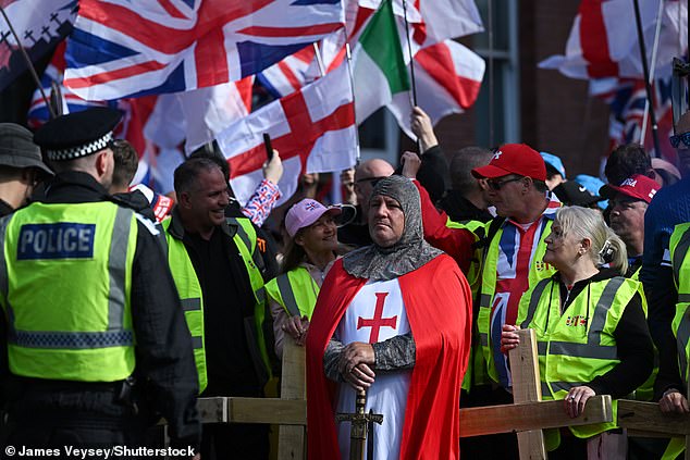Police officers monitor protesters in London dressed as medieval knights and carrying wooden crosses