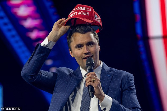 Charlie Kirk, Turning Point USA founder, puts on a MAGA hat during the AmericaFest 2024 conference