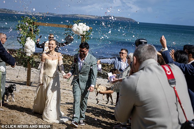 The guests threw confetti on the delighted pair as they walked down the aisle