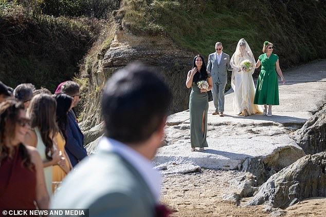 Becky was walked down the aisle by both her mum and dad while her bridesmaid wore olive