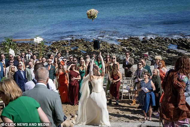 Becky threw her bouquet in the air while her colourfully-clad guests were seen vying for the flowers for the classic tradition