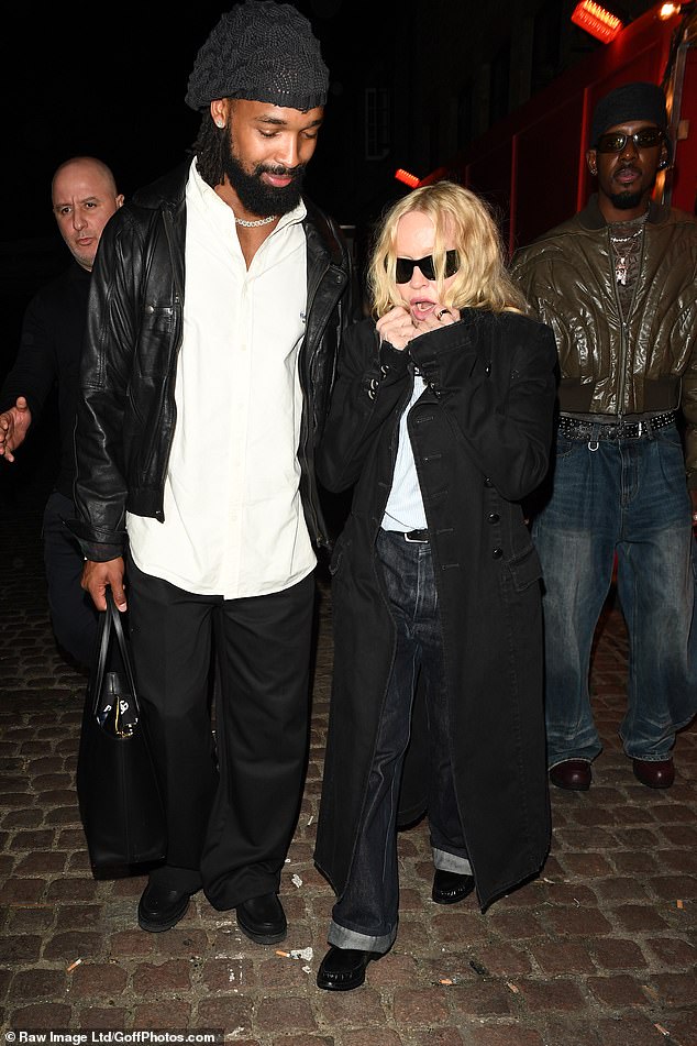 Madonna, 67, layered up with a black trench coat as she strutted into the bash alongside boyfriend Akeem Morris, 29.