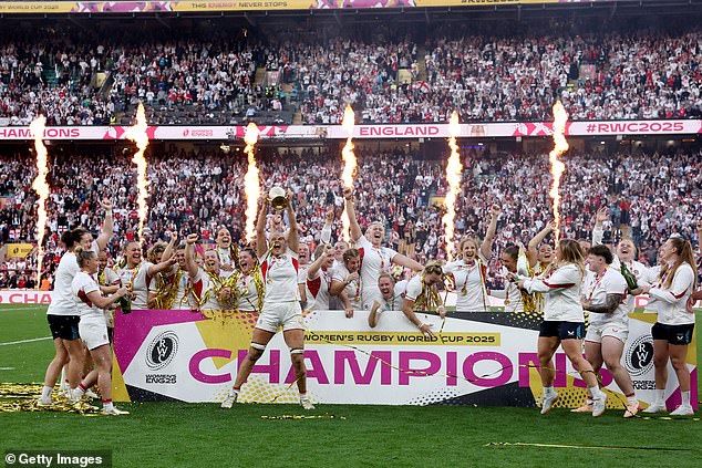 The England squad celebrate with their winners medals as Zoe Aldcroft of England lifts the Women's Rugby World Cup trophy