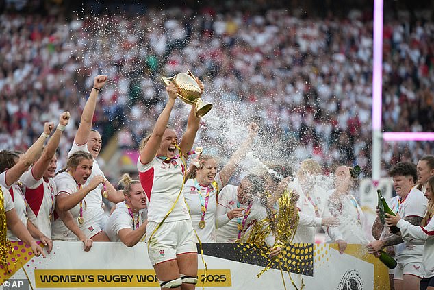 England's Zoe Aldcroft holds a trophy as she celebrates with her teammates after winning the Women's Rugby World Cup final