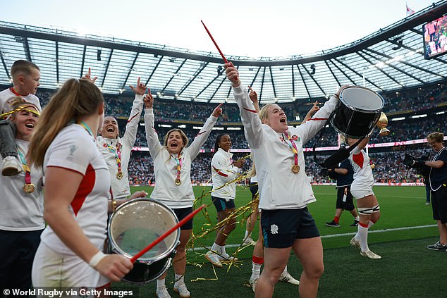 Abi Burton of England celebrates with teammates as she holds a drum after the squad's victory