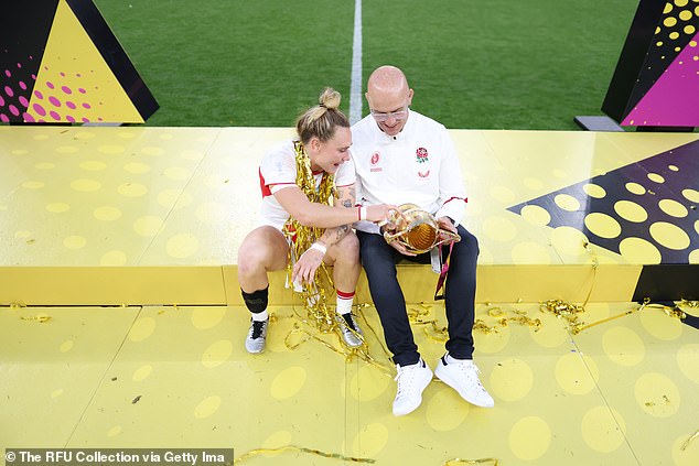 England player Megan Jones and head coach John Mitchell with the winners' trophy