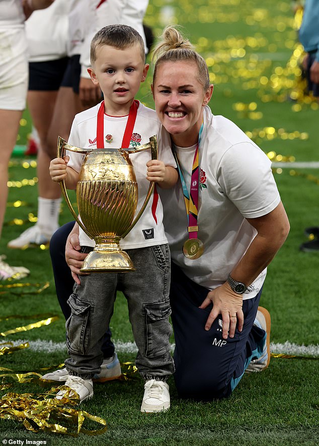 Marlie Packer of England poses for a photograph with her son Oliver and the Women's Rugby World Cup trophy