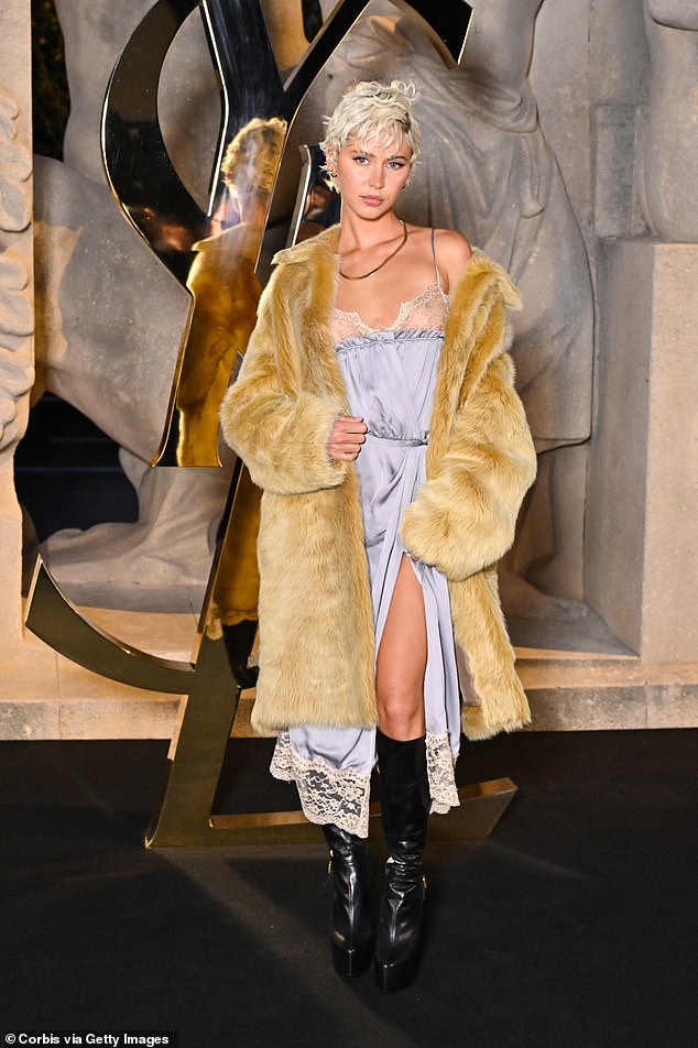 Iris put on a stylish display in a pale yellow maxi fur coat, flashing a silky lace midi dress underneath