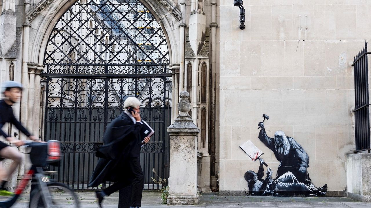 Banksy unveils a new mural of a judge beating a protester outside London court
