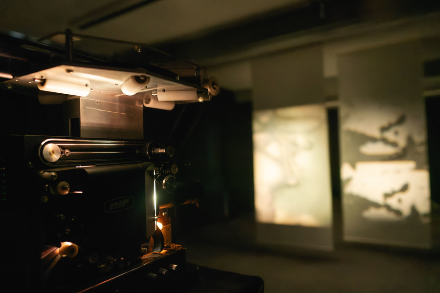 Photo of a projector projecting film onto a wall.