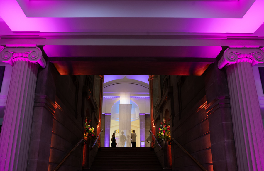 Photo of the Royal Scottish Academy at night, lit by purple lights.