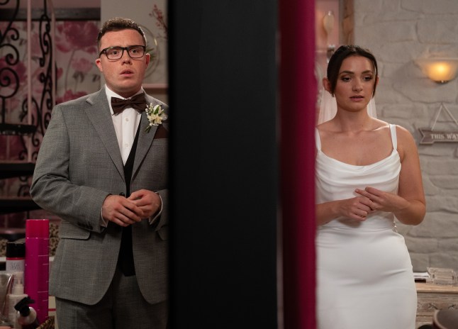 Vinny and Gabby standing in the salon and Take a Vow in their wedding outfits in Emmerdale