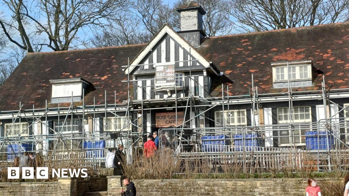 The Rose Garden Café in Graves Park, Sheffield, with customers queuing out of the door. Scaffolding surrounds the Tudor-style building.