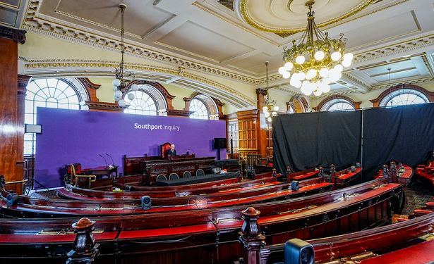 Chair Sir Adrian Fulford sitting inside the hearing room at Liverpool Town Hall