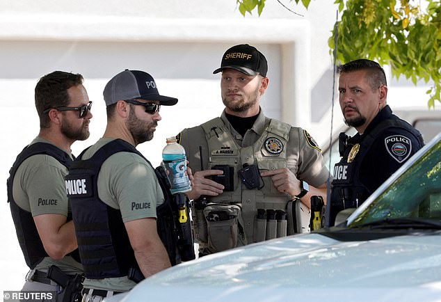 Washington City police officers and a Washington County sheriff's deputy confer outside a residence in Washington, Utah, associated with Tyler Robinson, the suspect in the fatal shooting of U.S. conservative commentator Charlie Kirk during an event at Utah Valley University, U.S., September 12, 2025.  REUTERS/Steve Marcus
