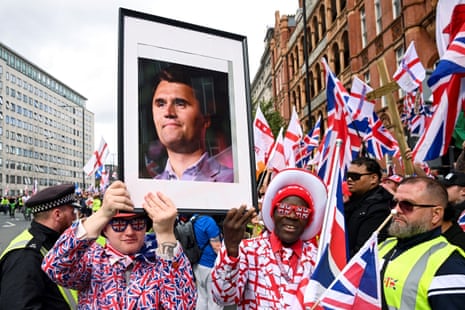 Men in union jack flag suits hold a picture of US conservative activist Charlie Kirk who was fatally shot earlier this week, as they attend the ‘unite the kingdom’ march in London.