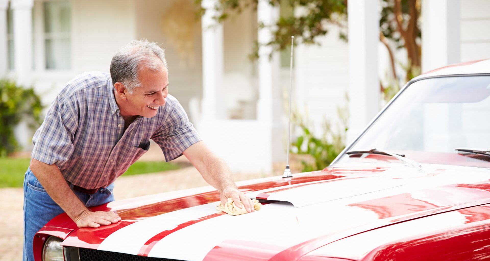 Retired man polishing vintage car