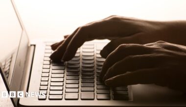 Hands typing on a laptop keyboard.
