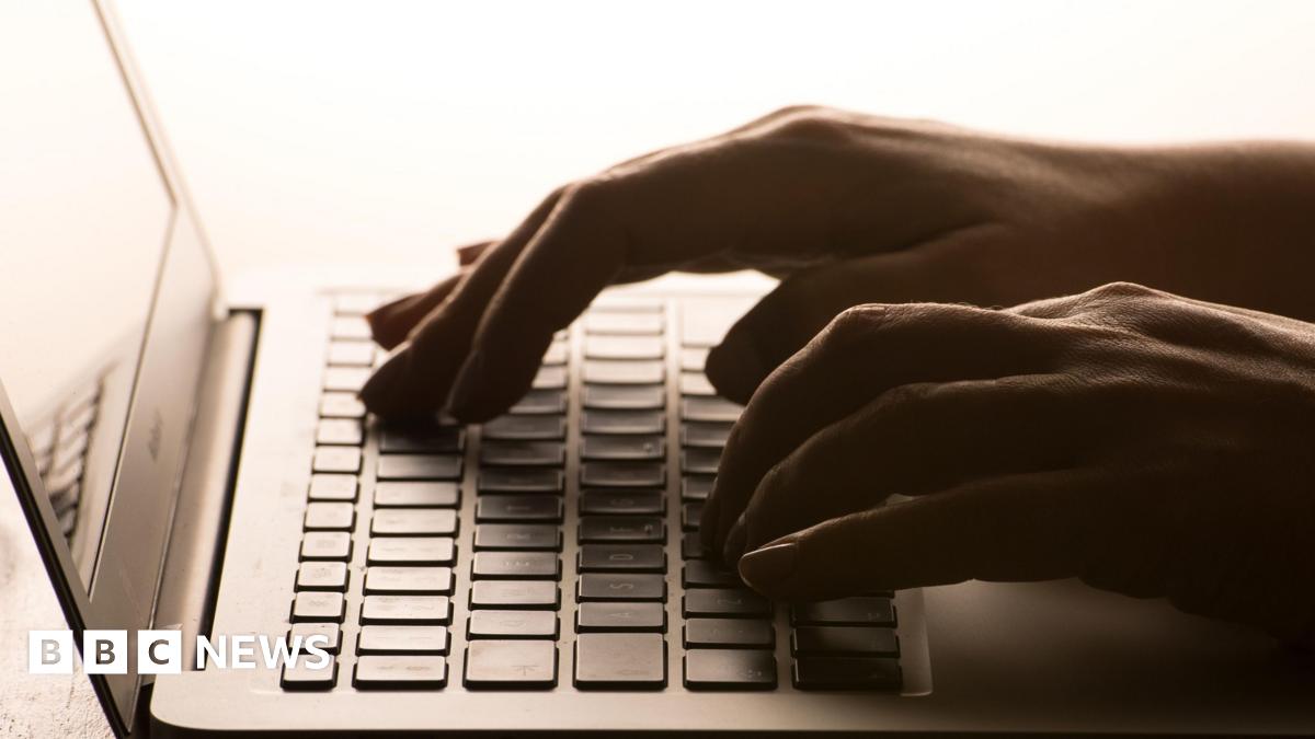 Hands typing on a laptop keyboard.